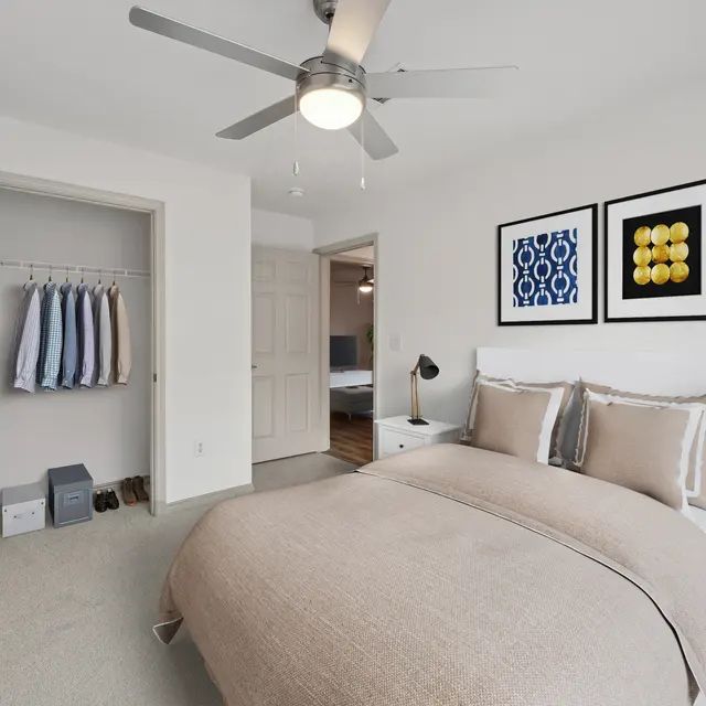 A bedroom with a large bed and a ceiling fan.